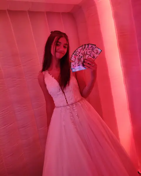 Quinceañera mostrando las fotos impresas que salieron de la cabina